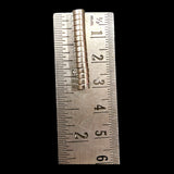 Stack of 5mm x 2mm neodymium disc magnets beside metric ruler on black background