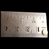 Single 5mm diameter neodymium round magnet on steel ruler showing exact size