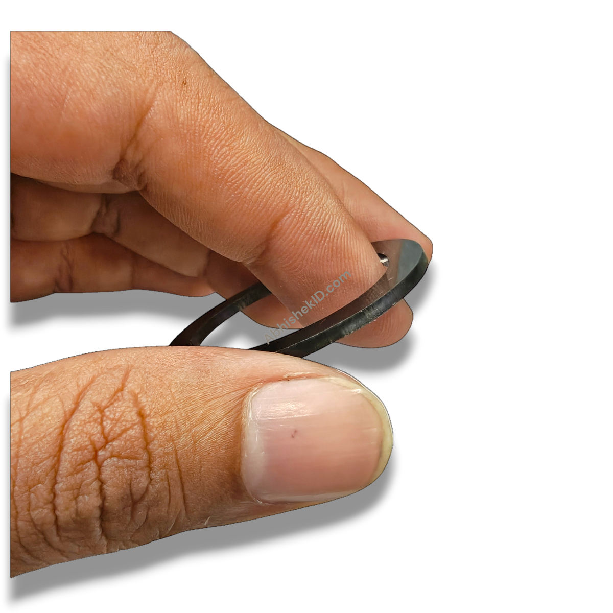 Hand holding a black Button Badge Ring 58mm/44mm die height washer spacer for badge press dies.