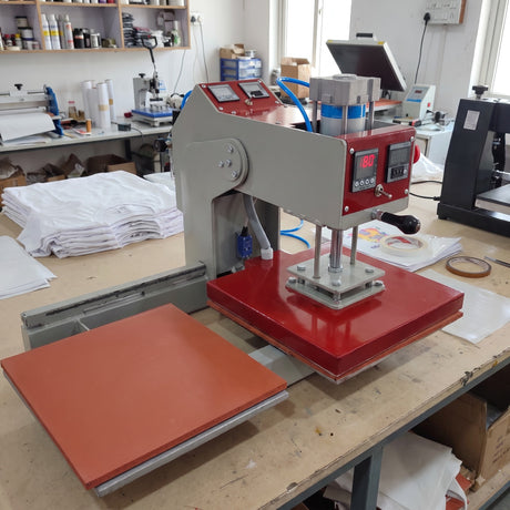 15x15 Automatic Double Bed Sublimation Heat Press, gray metal and red platen, for garment printing with white shirts.