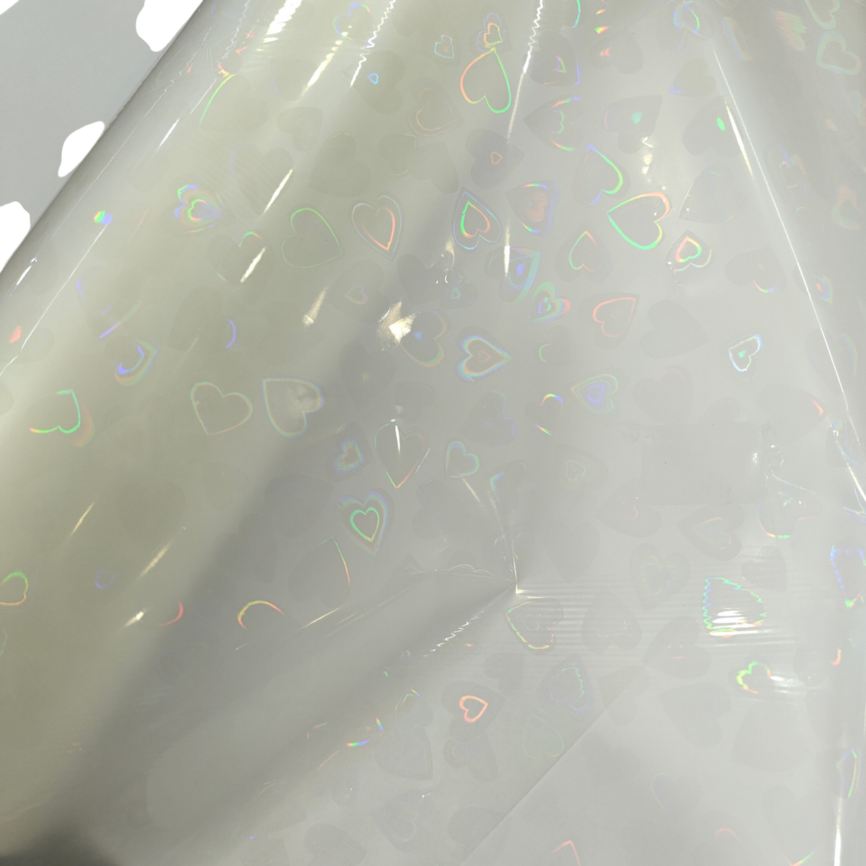 Holographic Heart Thermal Lamination Roll, clear film with iridescent heart pattern, 330MM x 100M x 27 Micron.