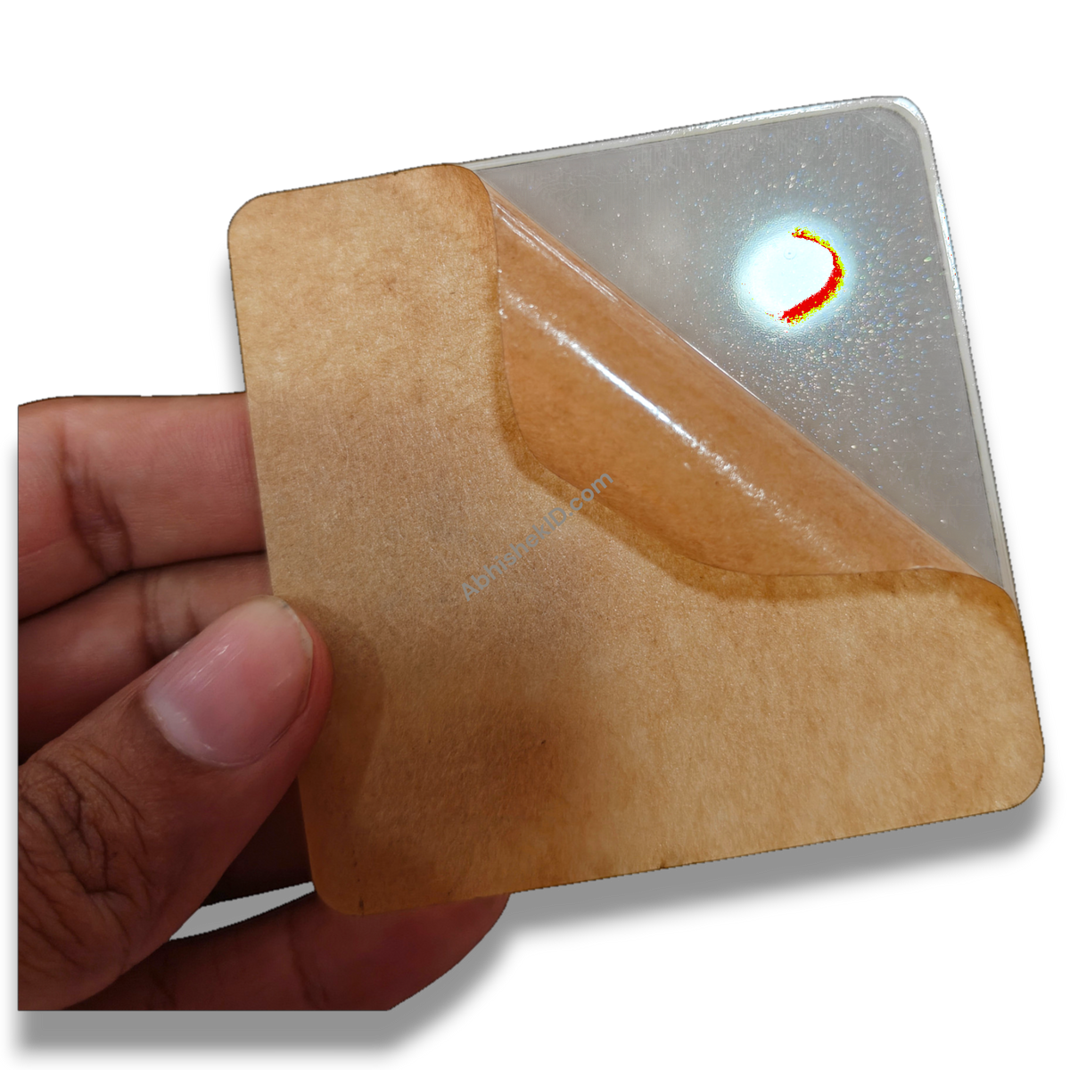 Hand holding 74mm square clear acrylic paperweight DIY blank for inserts, gifts, with protective film peeling.