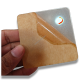 Hand holding 74mm square clear acrylic paperweight DIY blank for inserts, gifts, with protective film peeling.