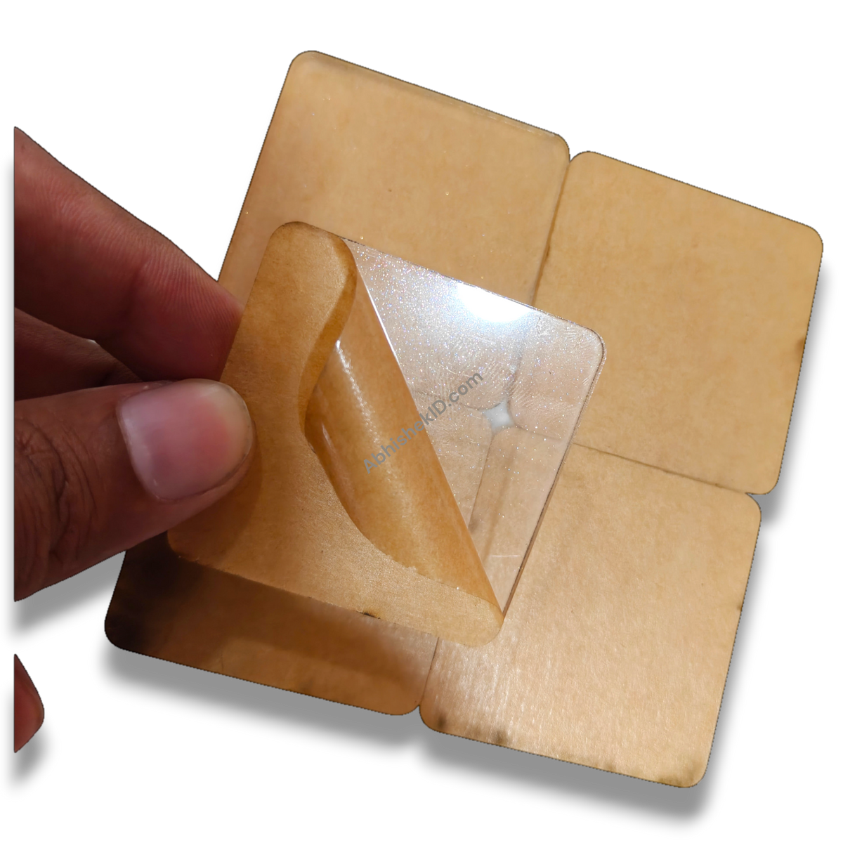 49mm acrylic puzzle DIY tiles, 2mm clear adhesive sparkle gumming square round-corner puzzle pieces, being peeled by hand.